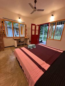 a bedroom with a large bed in a room with windows at PointBreak Resort in Kalpitiya