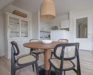 a dining room with a wooden table and chairs at Duinhof I 15 in Cadzand