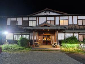 - un grand bâtiment en bois avec une porte la nuit dans l'établissement JetPoint Family Home, à Nadi