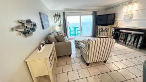 a living room with a couch and chairs and a television at The Summit 1426 in Panama City Beach