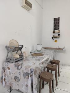 Una cocina con una mesa con taburetes y un mantel. en TDT STAY-Homestay, en Keningau