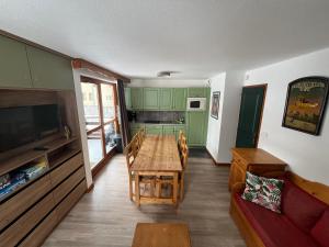 a kitchen with green cabinets and a wooden table at Chalet du Galibier Valloire in Valloire +55 photos