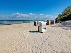a row of beach chairs and trash cans on a beach at Buchenweg Schaumkrone in Oertzenhof