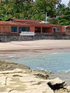 a house on the beach with the ocean at O De Casa in Japaratinga