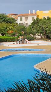 a row of swimming pools with blue water at Surf Beach Vila Verde apartments in Santa Maria