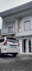 a white car parked in front of a building at Kanaya Homestay in Sukapura +6 photos