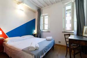 a bedroom with a bed and a desk with a desk at Appartamento nel Cuore del Centro Storico di Siena in Siena