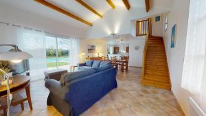 Una sala de estar con un sofá azul y una mesa. en Villa Emeraude - Golf & Plage, en Saint-Révérend