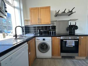 a kitchen with a sink and a washing machine at Central Halifax Work & Retreat Base - Two bedroom house - sleeps up to 4 - free parking and internet in Halifax