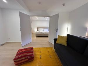 een woonkamer met een bank en een bed bij Silk House - Designerwohnung nahe Düsseldorf in Krefeld