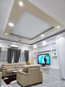 a living room with couches and a flat screen tv at Résidence Osiris in Cotonou