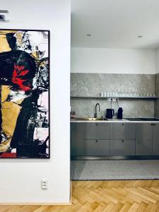 a kitchen with a large painting on the wall at Alexander library apartment in Košice