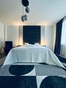 a bedroom with a large white bed with two lamps at Alexander library apartment in Košice