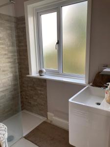 a bathroom with a window and a sink and a shower at The mole hole in Kent
