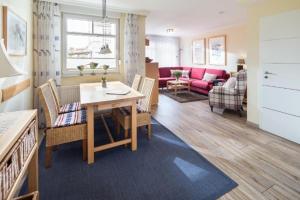 a living room with a table and a couch at Haus Anna-Margarete in Norderney
