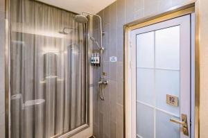 una doccia in un bagno con una porta in vetro di Yihai Cultural Hotel Coffee, fruits, snacks, a gym and a laundry room are provided for free in the lobby a Pechino