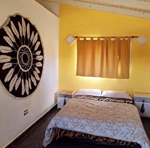 a bedroom with a bed and a painting on the wall at Cabaña Los Pinos in Villa Icho Cruz