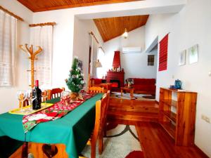 a dining room with a table and a christmas tree at Το μπαλκόνι της Βεγορίτιδας in Agios Panteleimon