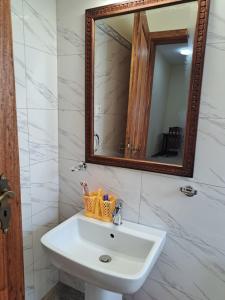 a bathroom with a white sink and a mirror at Diamond Coast Villa and Apartment in Paje