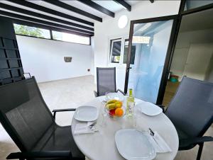 a white table with a bowl of fruit on it at Casa Los Volcanes a primera línea del mar in Teguise