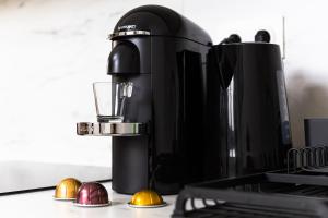a black coffee maker sitting on a counter with balls at Jacuzzi Romantique, Cosy, Home Cinéma, Paris 10min in Clichy +20 photos