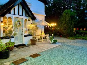a small house with a table and an umbrella at Storrs Gate House B & B No pets Allowed in Bowness-on-Windermere +137 photos