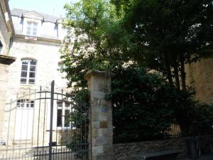 un portail en face d'un bâtiment avec une clôture dans l'établissement Appartement de charme coeur historique parking privé, à Vannes