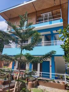a building with a palm tree in front of it at Princesa Michaella Hostel in Itaytay