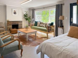 a bedroom with a bed and a living room with a fireplace at Stones - Cape Town Self Catering in Cape Town