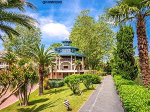 a large house with a blue roof and palm trees at Appartement T1 Bis avec Terrasse et Piscine à Cambo-les-Bains, 1 Chambre, Parking Privé - FR-1-495-4 in Cambo-les-Bains