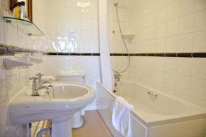 a bathroom with a sink and a toilet and a tub at The Riviera Hotel & Apartments - Alum Chine in Bournemouth