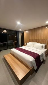 a bedroom with a large bed with a wooden headboard at Widji Garden Villa in Uluwatu