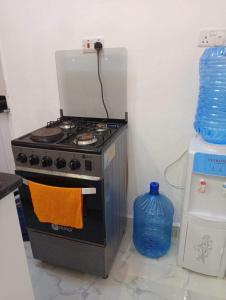 a kitchen with a stove with an orange towel at Traven Homes - 1BR Unit in Nairobi