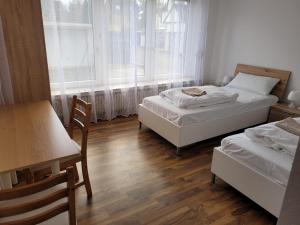 a bedroom with two beds and a table and a table and chairs at Horrem City Apartments in Horrem
