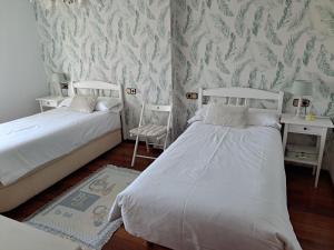 2 camas en una habitación con papel pintado en LA BUGANVILLA, en Gijón