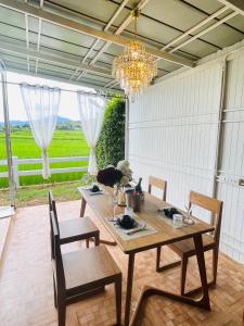 a dining room with a table and chairs and a chandelier at Area 21 ปัว in Pua +93 photos