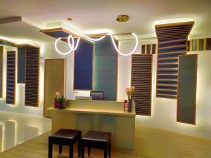 a lobby with a reception desk with windows and stools at Eastique Hotel Koh Chang in Trat