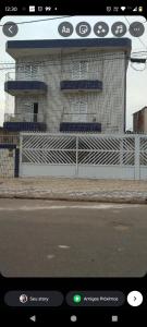 a view of a building with a fence and a street at Apartamento na praia grande in Praia Grande
