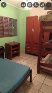 a room with a bunk bed and a table at Apartamento na praia grande in Praia Grande