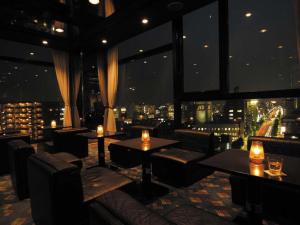 a restaurant with tables and chairs and a view of the city at Marroad Inn Kumagaya in Koizumi