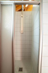 a shower with a glass door and white tiles at Raddörfl in Teufenbach +60 photos