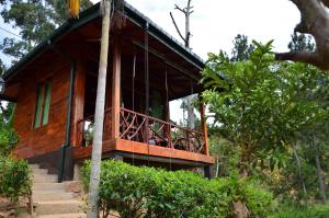 a house with a balcony in the forest at Ella Mount Relax Cottage in Ella
