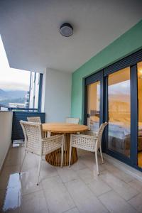 a table and chairs in a room with a balcony at Central Suite in Trebinje