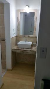 y baño con lavabo y espejo. en Departamento Neuquen en Neuquén