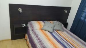 Una cama con dos almohadas encima en un dormitorio. en Departamento Neuquen, en Neuquén