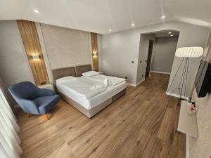 Family Hotel Delta في أوجنيانوفو: غرفة نوم بها سرير وكرسي أزرق