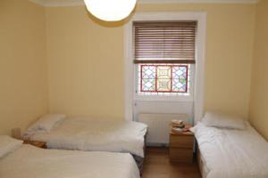 a room with two beds and a window in it at The Weymouth Sea Front Holiday Flat in Weymouth