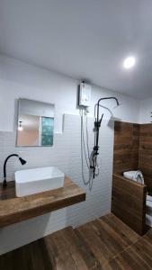 a bathroom with a white sink and a mirror at Dollar Betong homestay in Ban Komo Sip Paet