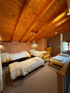 a room with four beds and a brick wall at Complejo Entre Olmos in Santa Rosa de Calamuchita +42 photos
