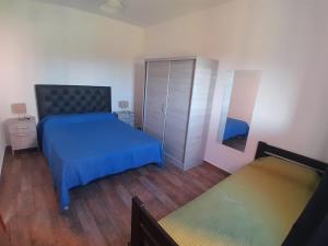 ein Schlafzimmer mit einem blauen Bett und einem Spiegel in der Unterkunft Complejo Las Liebres in San Lorenzo